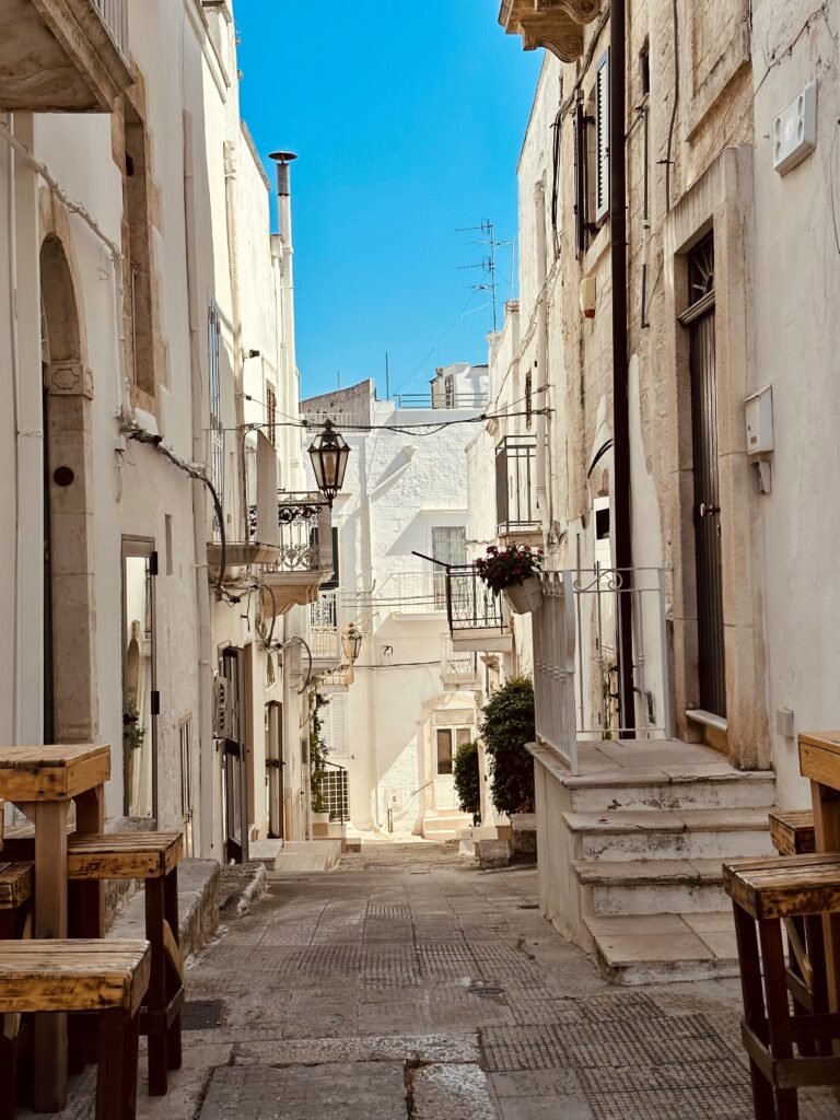 Vicolo del centro storico di Polignano a Mare con case bianche, balconi e atmosfera autentica